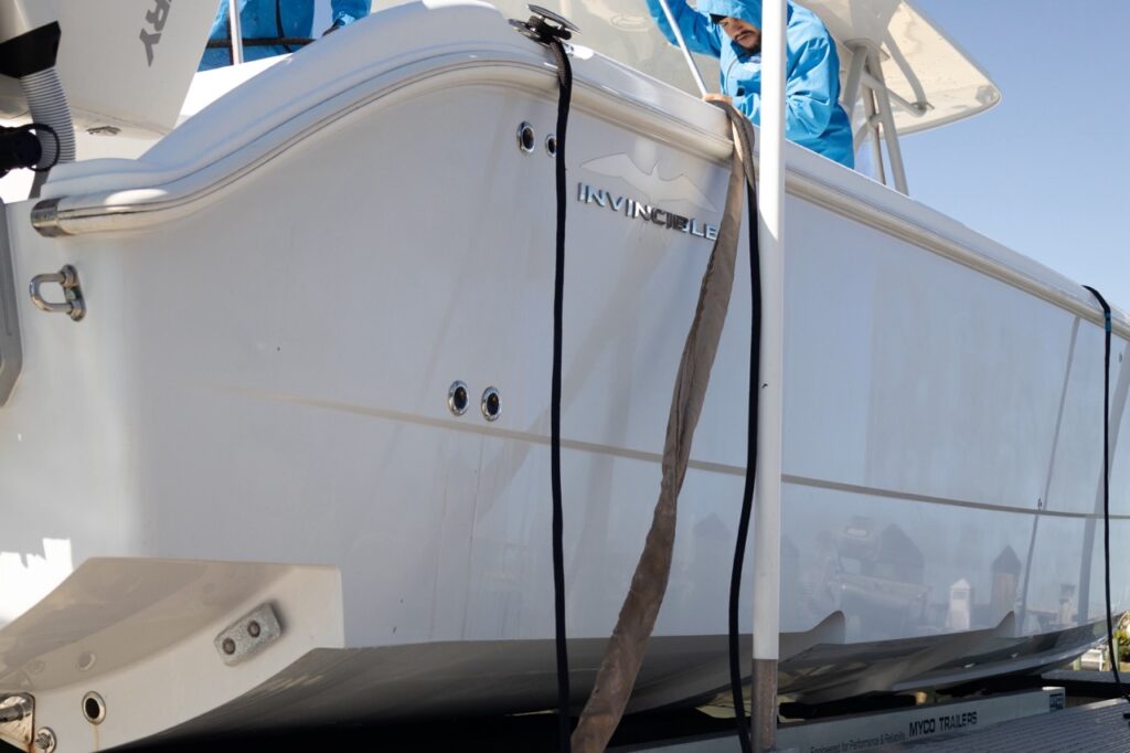 Center console boat hull side during mobile boat detailing at the dock