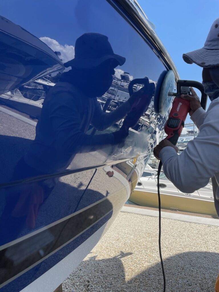Technician machine-polishing a boat hull in Sarasota, FL